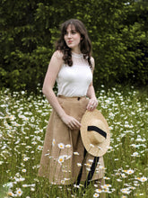 A lady wears a white tank top.